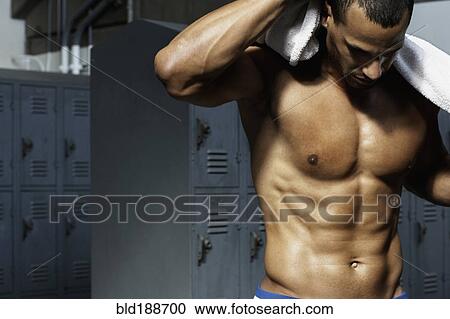 Stock Image - Bare chested mixed race man in locker room. Fotosearch