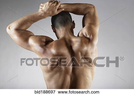 Stock Photo - Bare chested mixed race man with arms raised. Fotosearch