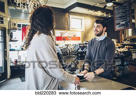 Barista serving customer coffee in cafe View Large Photo Image Stock Image - Barista serving customer coffee in cafe. Fotosearch