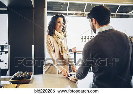 Stock Photography - Barista serving customer coffee in cafe. Fotosearch