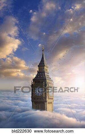 Stock Image - Birds flying around clock tower above clouds. Fotosearch