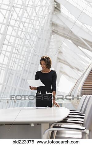 Black businesswoman reading in conference room View Large Photo Image Stock Photograph - Black businesswoman reading in conference room. Fotosearch