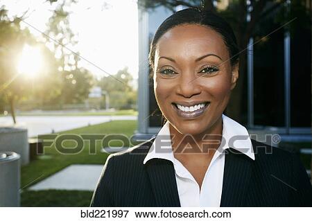 Stock Photo - Black businesswoman smiling outdoors. Fotosearch