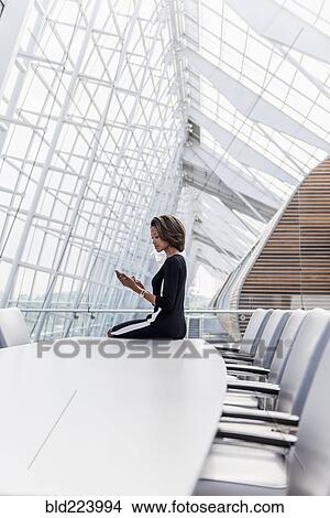Picture - Black businesswoman using cell phone in conference room. Fotosearch