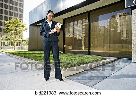 Stock Image - Black businesswoman using digital tablet outdoors. Fotosearch
