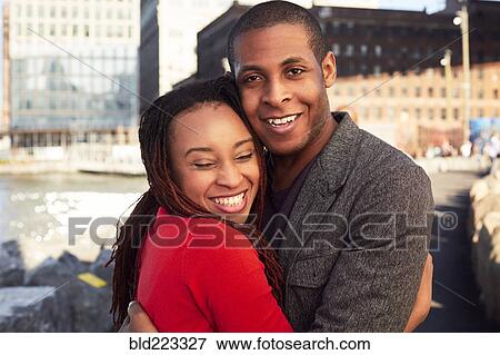 Stock Photo - Black couple hugging at waterfront. Fotosearch