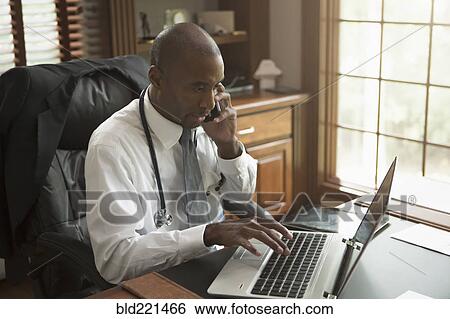 Stock Photograph - Black doctor talking on cell phone in office. Fotosearch