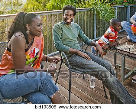 Black family relaxing on patio View Large Photo Image Stock Photography - Black family relaxing on patio. Fotosearch