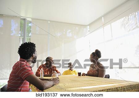 Black family sitting at dining room table View Large Photo Image Stock Photo - Black family sitting at dining room table. Fotosearch