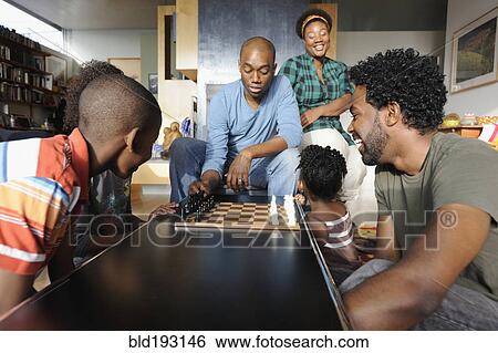Stock Photograph - Black family watching chess game. Fotosearch