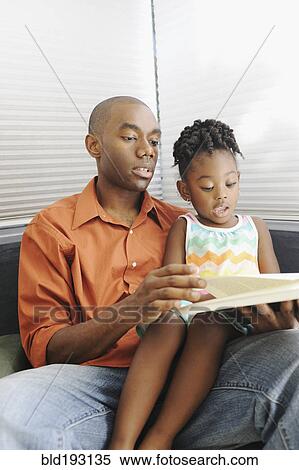 Black father reading book to daughter View Large Photo Image Stock Photography - Black father reading book to daughter. Fotosearch