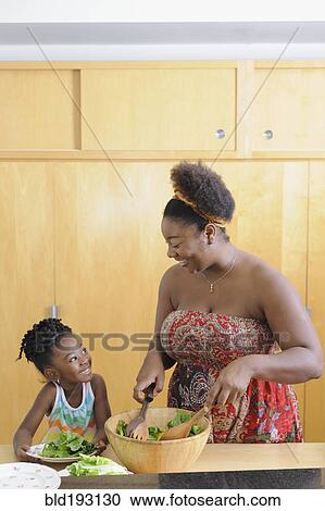 Black girl with mother preparing salad in kitchen View Large Photo Image Stock Image - Black girl with mother preparing salad in kitchen. Fotosearch