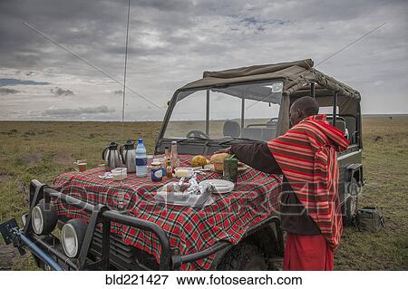 Black man having picnic on hood of car in remote field View Large Photo Image Stock Photo - Black man having picnic on hood of car in remote field. Fotosearch