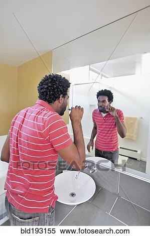 Black man in bathroom brushing teeth View Large Photo Image Stock Photography - Black man in bathroom brushing teeth. Fotosearch