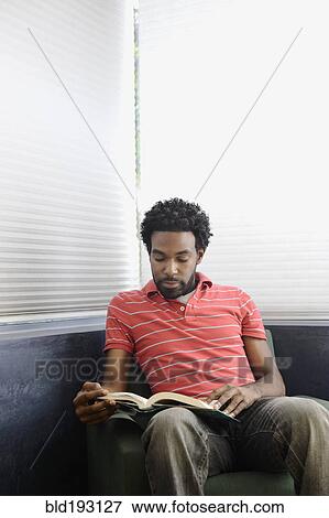 Stock Photo - Black man reading book. Fotosearch