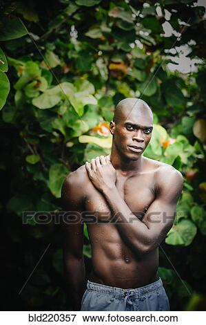 Black man standing in lush garden View Large Photo Image Stock Photo - Black man standing in lush garden. Fotosearch