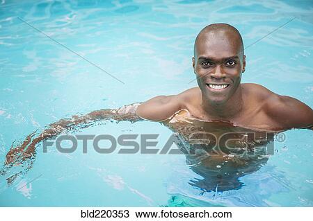Stock Image - Black man swimming in pool. Fotosearch