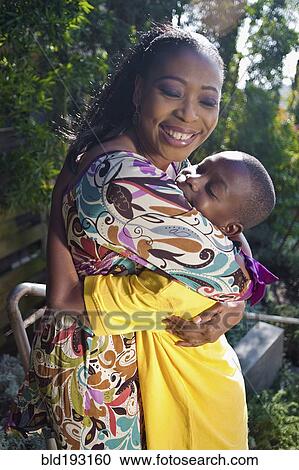Stock Image - Black mother hugging son outdoors. Fotosearch