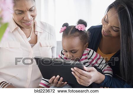 Black multi-generation family using digital tablet View Large Photo Image Stock Image - Black multi-generation family using digital tablet. Fotosearch