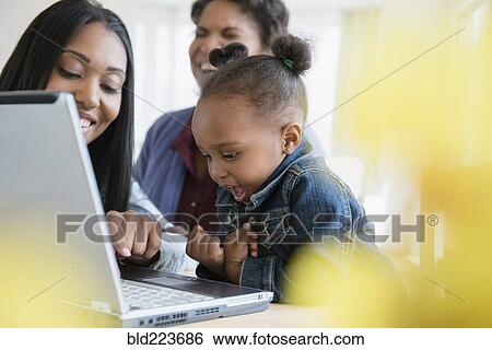 Stock Photograph - Black multi-generation family using laptop. Fotosearch