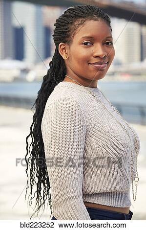 Stock Image - Black woman posing at waterfront. Fotosearch