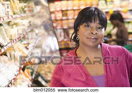 Stock Photography - Black woman shopping in grocery store. Fotosearch