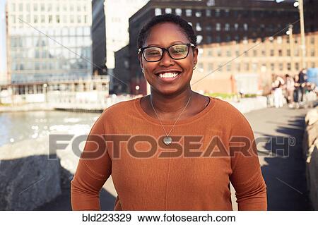 Stock Photo - Black woman smiling at waterfront. Fotosearch