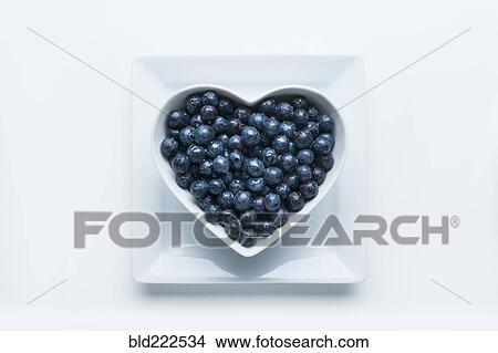 Picture - Blueberries in heart-shape bowl on white background. Fotosearch