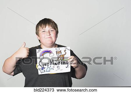Stock Image - Boy holding sign gesturing thumbs-up. Fotosearch