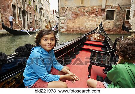 Stock Photo - Boy sitting in gondola on Venice canal, Veneto, Italy. Fotosearch