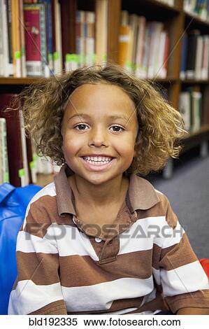 Stock Photography - Boy smiling in library. Fotosearch