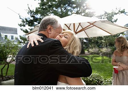 Stock Image - Bride and groom hugging on wedding day. Fotosearch