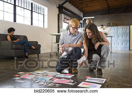 Business people examining paperwork on office floor View Large Photo Image Stock Photography - Business people examining paperwork on office floor. Fotosearch