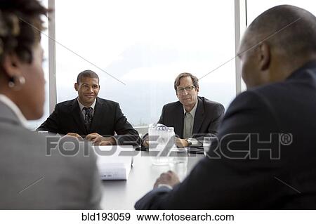 Stock Photo - Business people in meeting in conference room. Fotosearch