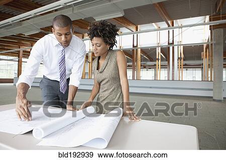 Stock Photo - Business people looking at blueprints. Fotosearch