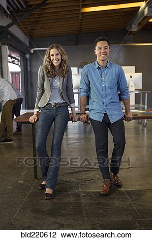 Stock Image - Business people smiling in office. Fotosearch