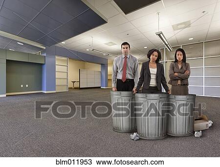 Stock Image - Business people standing with garbage cans in empty office. Fotosearch