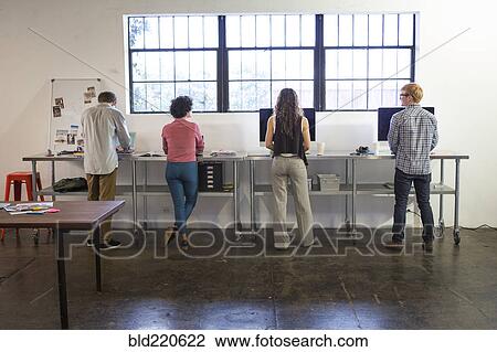 Business people working at desks in office View Large Photo Image Stock Image - Business people working at desks in office. Fotosearch