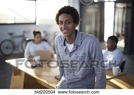 Businessman smiling in office View Large Photo Image Picture - Businessman smiling in office. Fotosearch