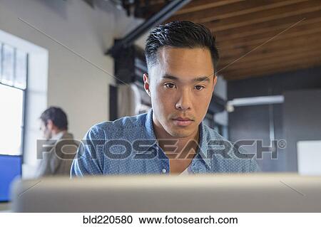 Stock Image - Businessman working at computer in office. Fotosearch