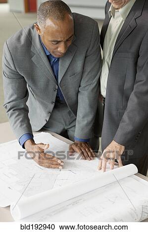 Businessmen looking at blueprints View Large Photo Image Stock Image - Businessmen looking at blueprints. Fotosearch