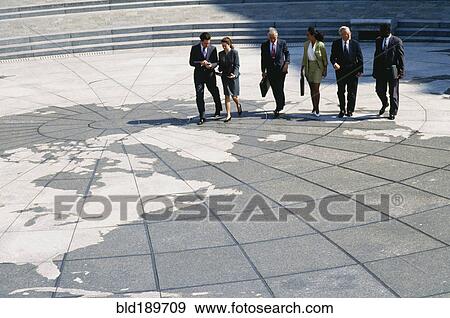 Stock Photo - Businesspeople walking on map of globe. Fotosearch