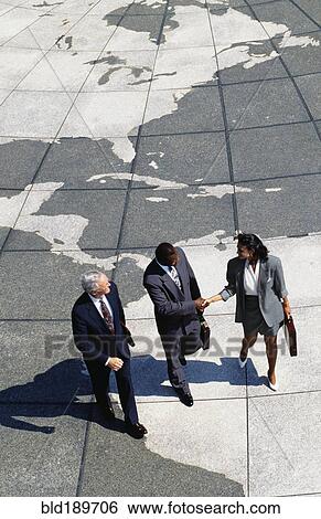 Businesspeople walking on map of globe View Large Photo Image Stock Photograph - Businesspeople walking on map of globe. Fotosearch