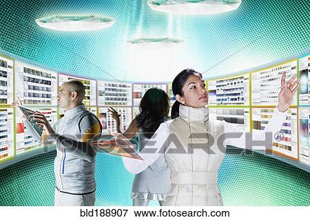 Businesspeople working at futuristic control panels View Large Photo Image Stock Photo - Businesspeople working at futuristic control panels. Fotosearch