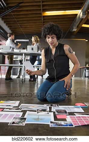 Businesswoman examining paperwork on office floor View Large Photo Image Stock Image - Businesswoman examining paperwork on office floor. Fotosearch