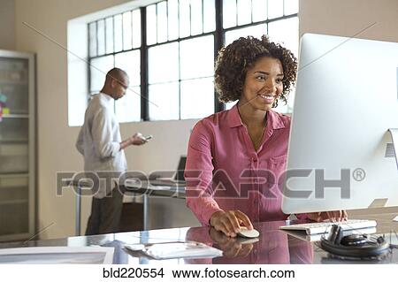 Picture - Businesswoman using computer in office. Fotosearch