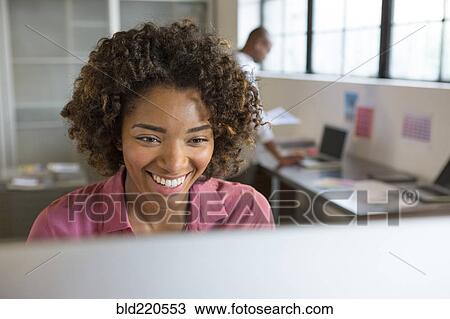 Stock Image - Businesswoman using computer in office. Fotosearch