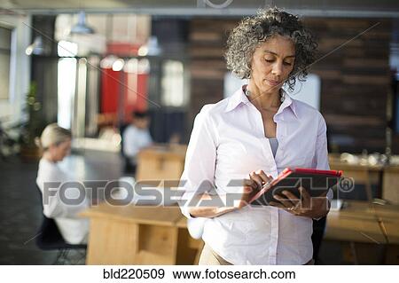 Businesswoman using digital tablet in office View Large Photo Image Stock Photo - Businesswoman using digital tablet in office. Fotosearch