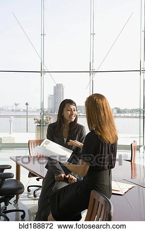 Stock Image - Businesswomen in conference room for meeting. Fotosearch