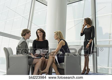 Picture - Businesswomen sitting in armchairs talking. Fotosearch
